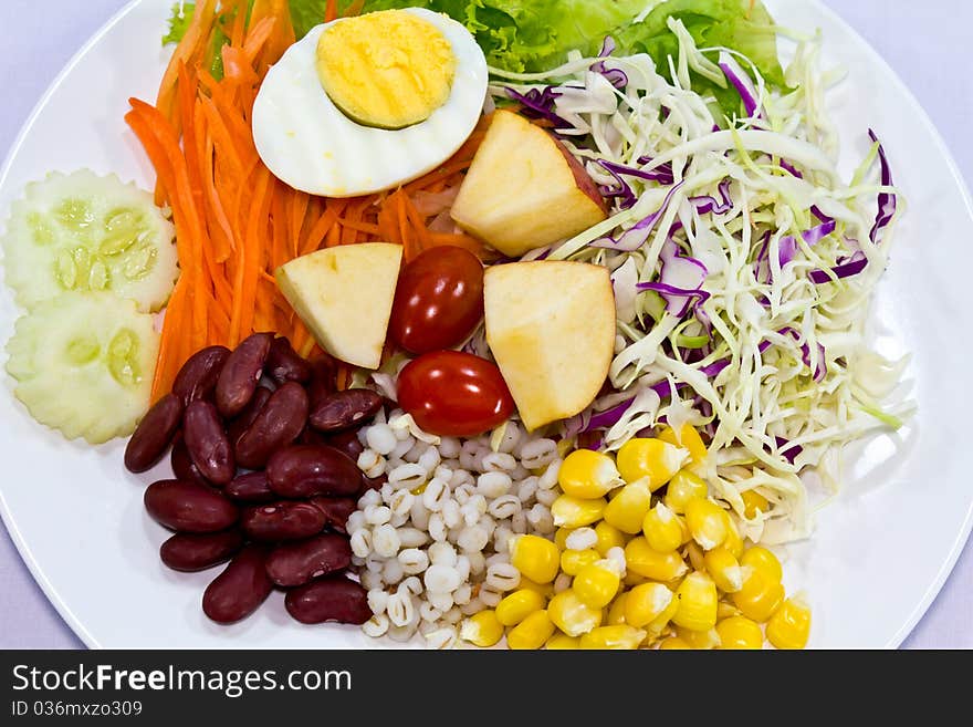 Fruit salad with boiled egg on a white plate