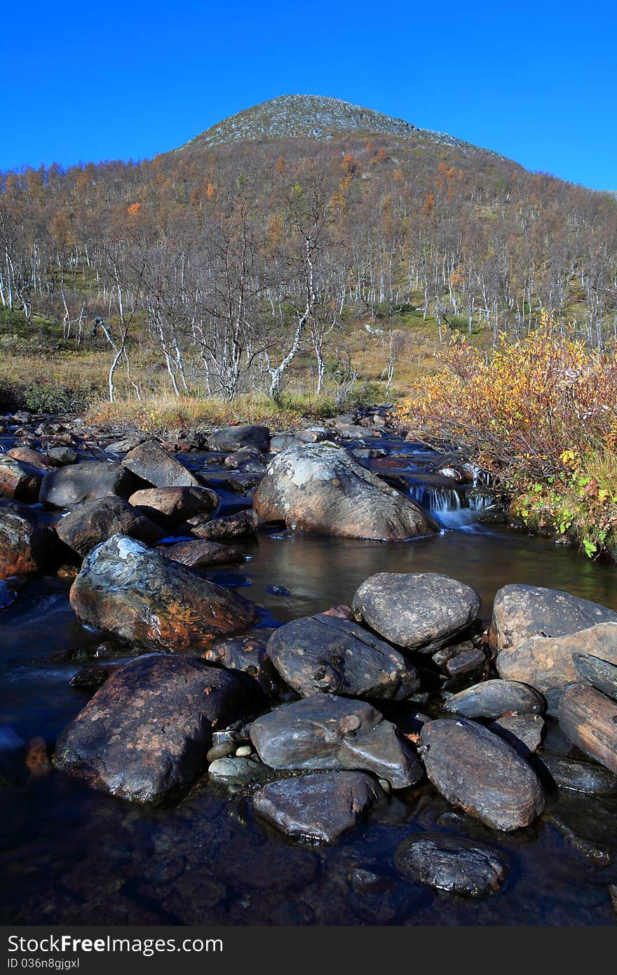 Flowing stream with a mountain top in the background. Flowing stream with a mountain top in the background