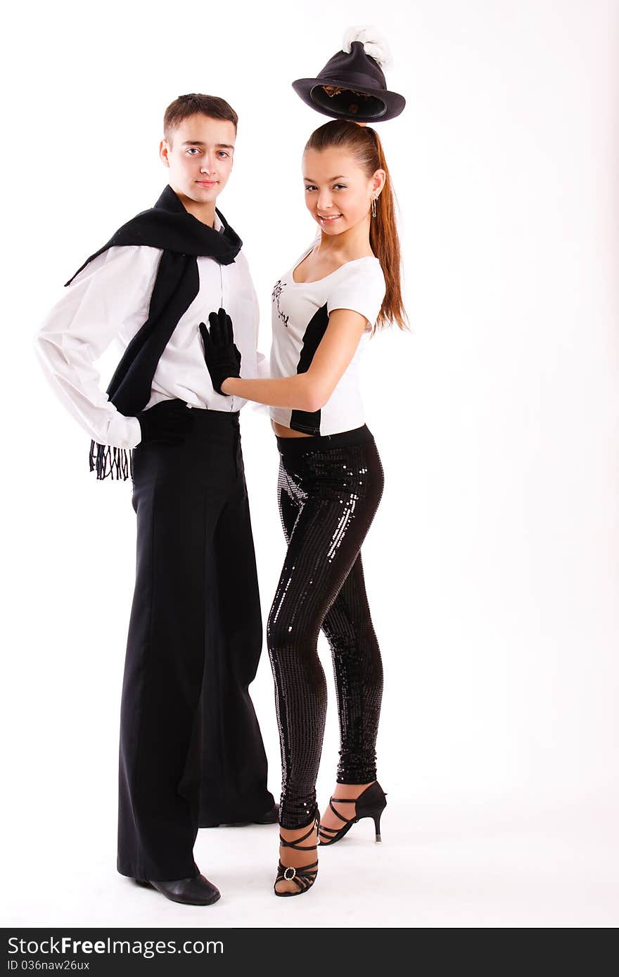 A beautiful young pair in good-looking suits dances on a white background. A beautiful young pair in good-looking suits dances on a white background