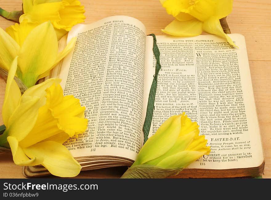 Antique prayer book open on Easter prayers surrounded by yellow daffodil flowers. Antique prayer book open on Easter prayers surrounded by yellow daffodil flowers