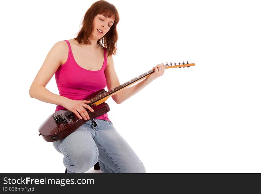 A beautiful young woman is playing a guitar. A beautiful young woman is playing a guitar