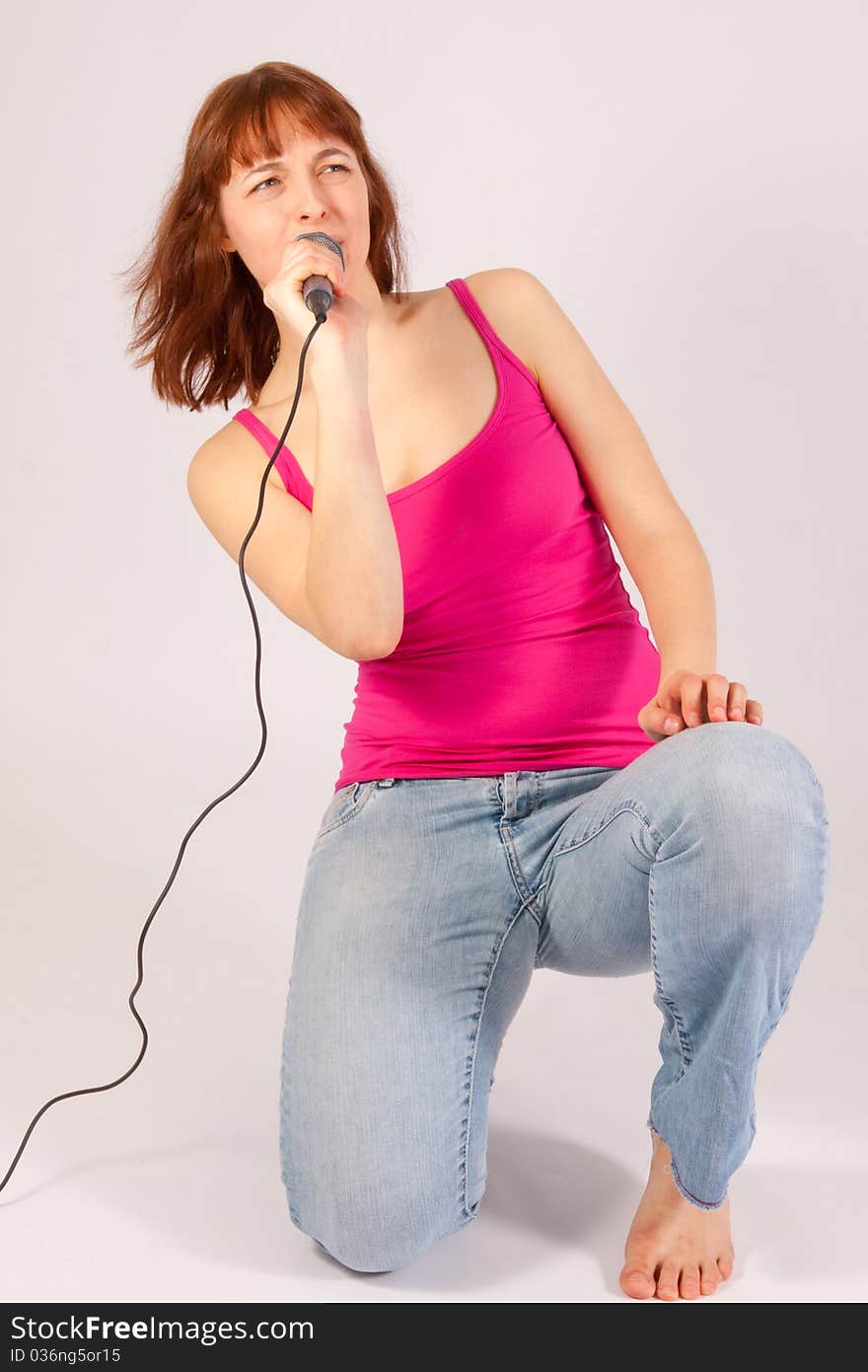 A beautiful young woman with a microphone in her hand. A beautiful young woman with a microphone in her hand