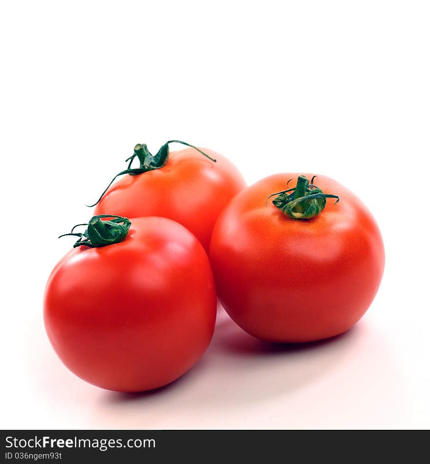 Three red tomatoes on white background