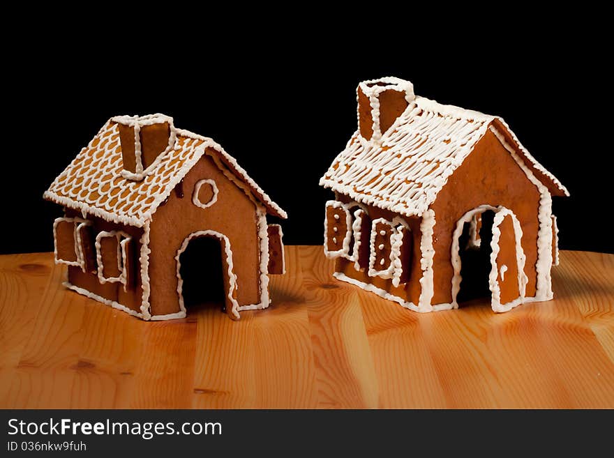 Two Isolated christmas gingernut house on wooden table