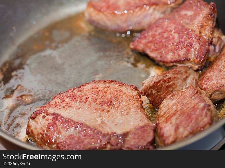 Meat is fried on a frying pan,  close up. Meat is fried on a frying pan,  close up