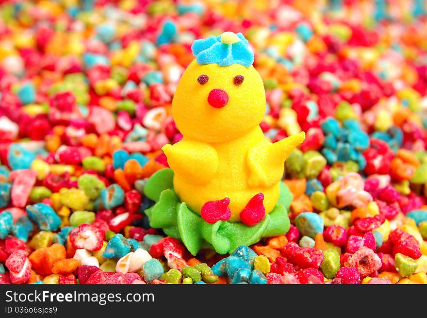 Chicken from sugar against decorative colorful candy sprinkles. Chicken from sugar against decorative colorful candy sprinkles