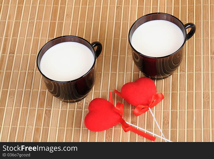 Two cups with milk and hearts