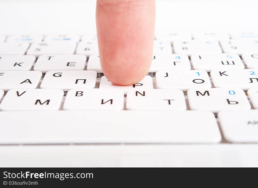 Human finger on a laptop keyboard. Press a key