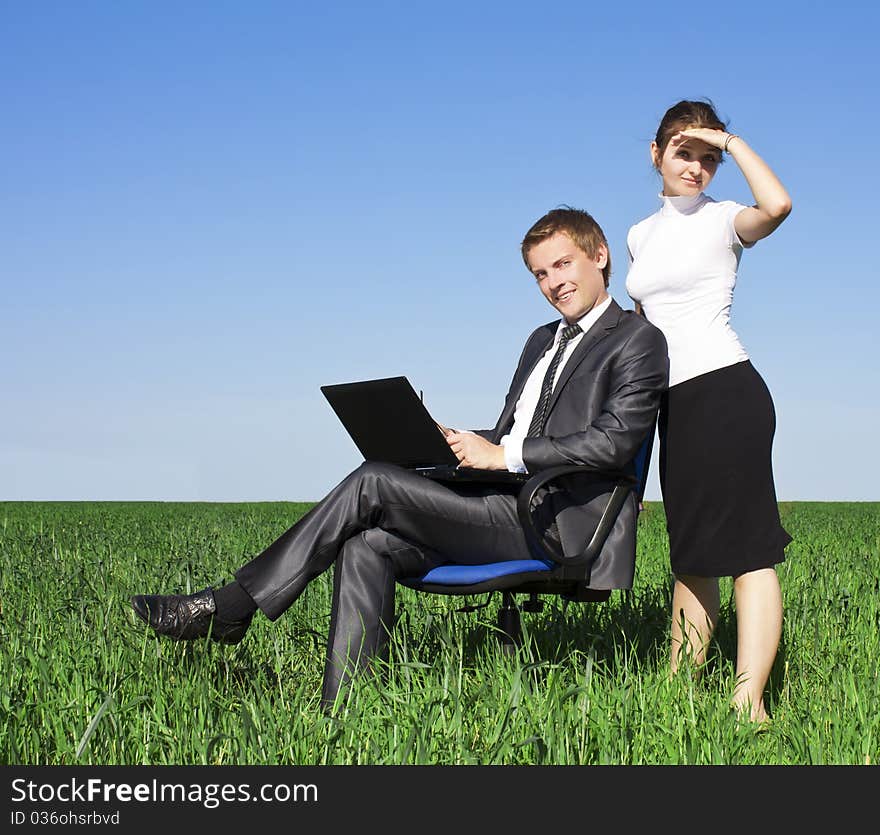 Happy young businessman on spring field