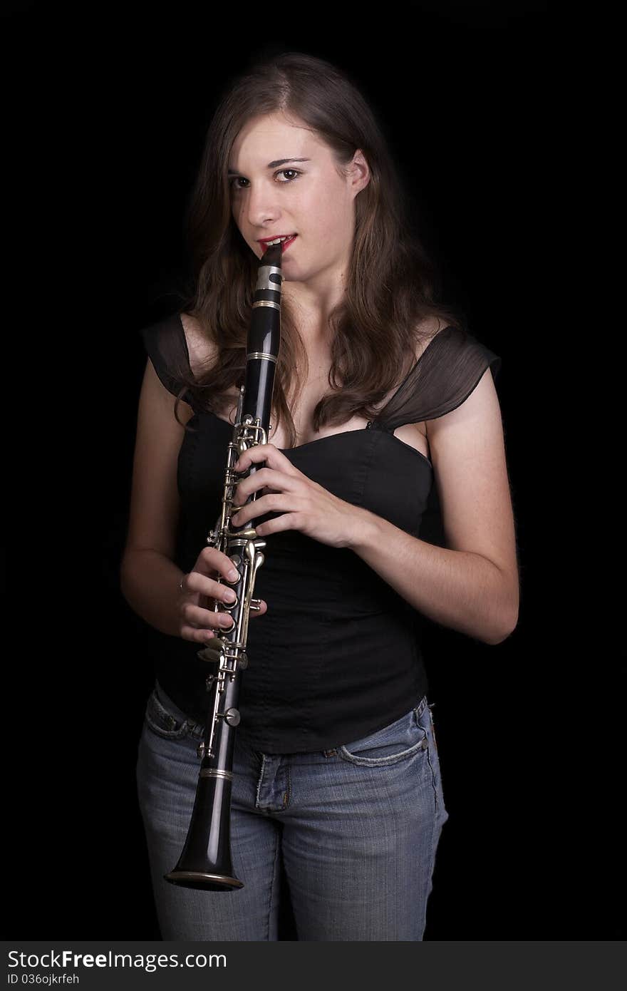 A young girl plays the clarinet - low key. A young girl plays the clarinet - low key