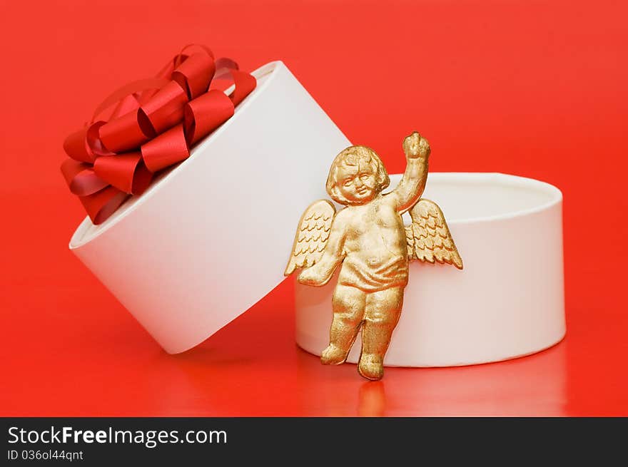 Box with a gift on a red background still life