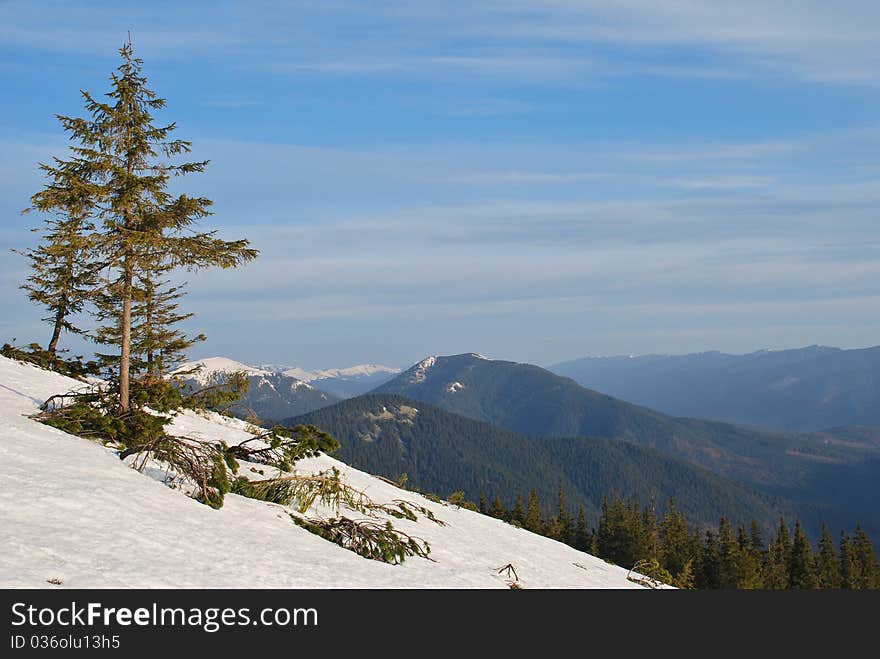 Spring in mountains in a landscape with hillsides under clouds