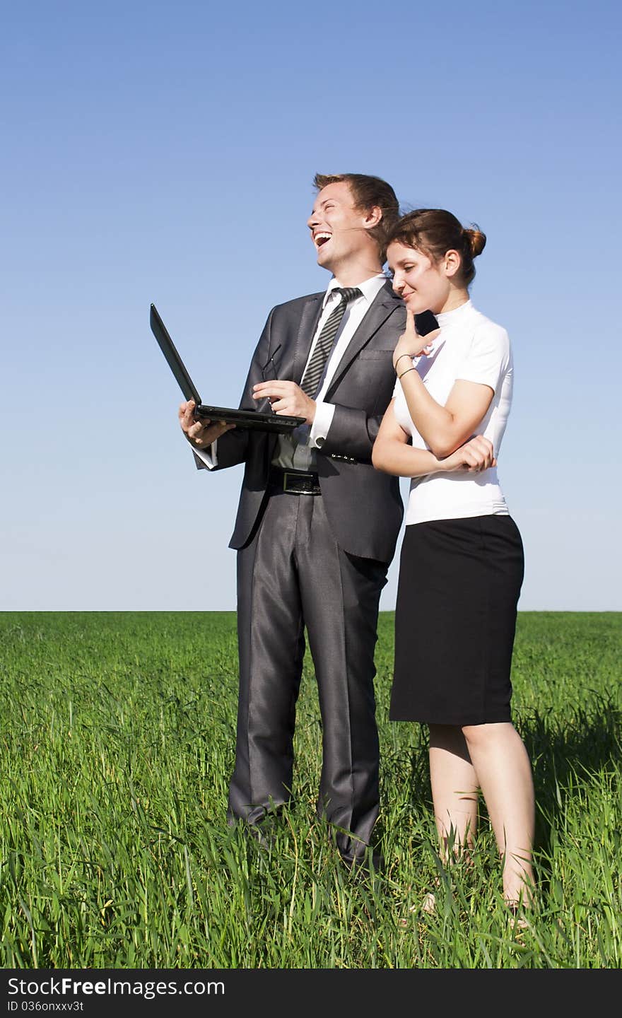 Portrait of businesswoman and businessman looking at monitor of laptop outdoor. Portrait of businesswoman and businessman looking at monitor of laptop outdoor