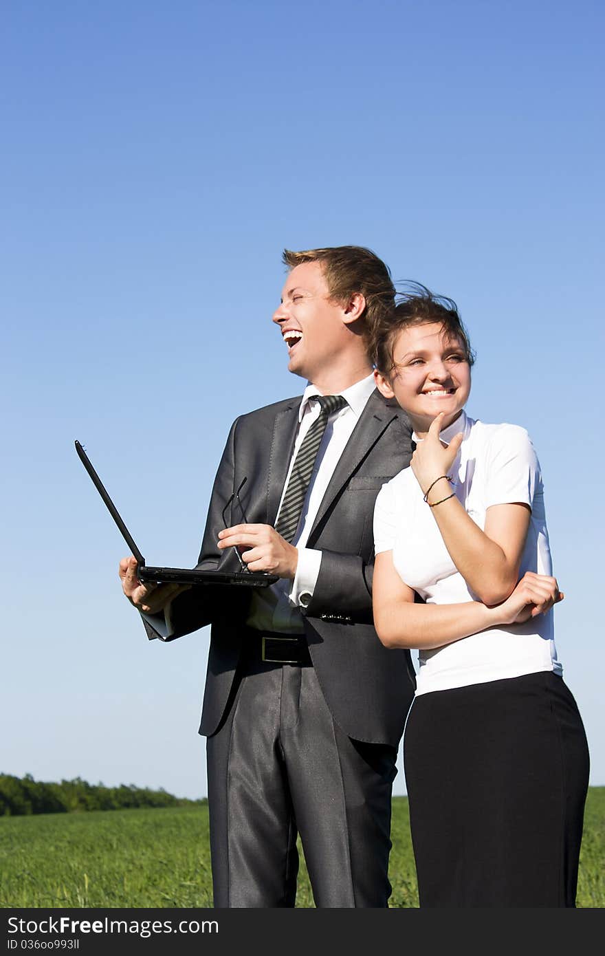 Two successful workers in the street with a laptop. Two successful workers in the street with a laptop