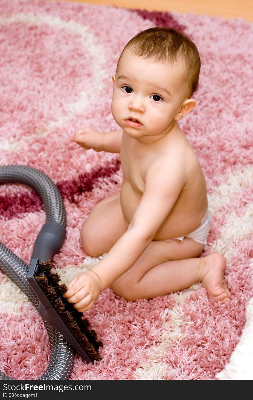 Cute caucasian baby with vacuum cleaner