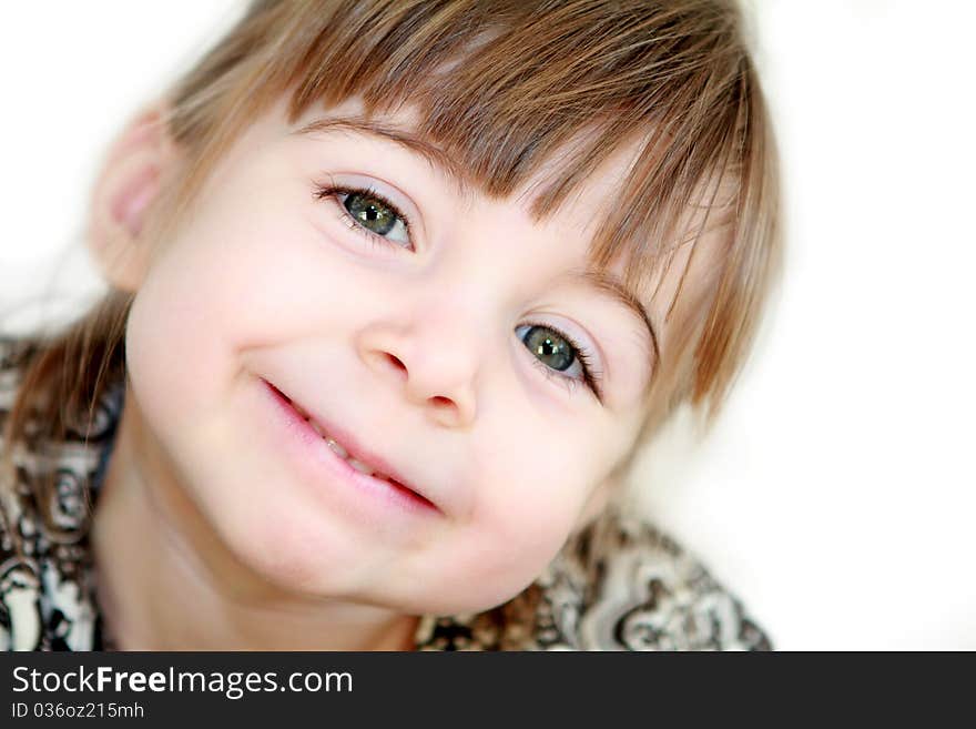 A beautiful 3 year old little girl smiling at the camera with her hed tilted. A beautiful 3 year old little girl smiling at the camera with her hed tilted