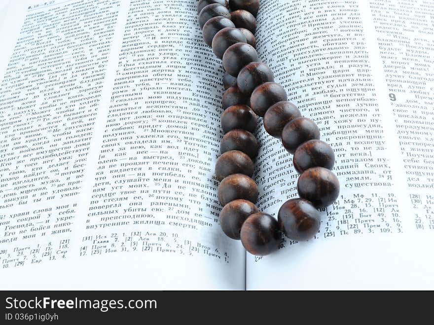 Bible open overhand lies wooden rosary beads. Bible open overhand lies wooden rosary beads