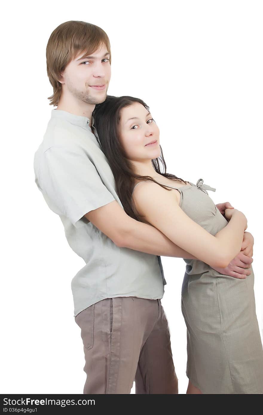 Beautiful young girl hugging her young man on a white background. Beautiful young girl hugging her young man on a white background