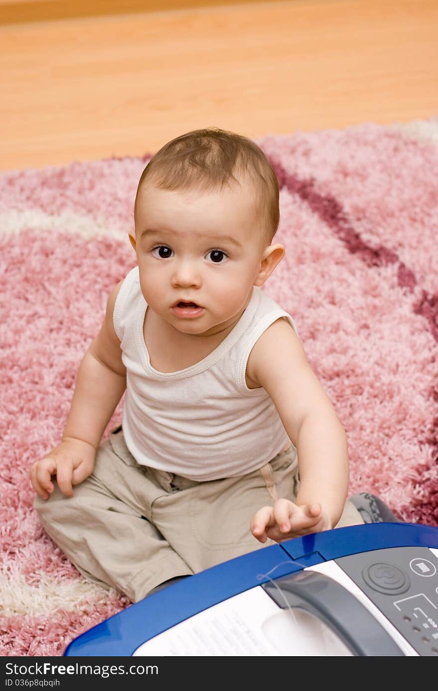 Cute caucasian baby with vacuum cleaner