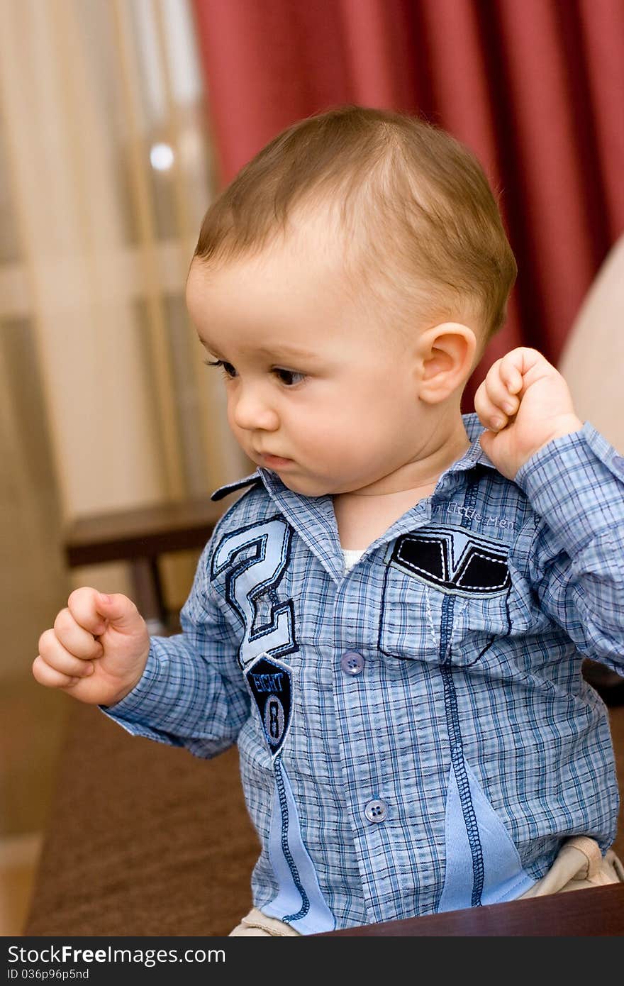 Cute caucasian baby in blue shirt in room