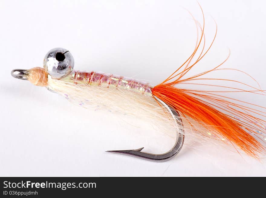 Orange bead head salt water fly isolated on a white background. Orange bead head salt water fly isolated on a white background