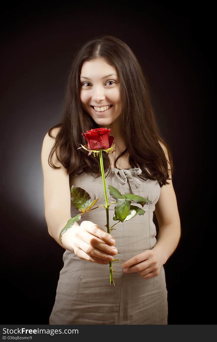 Beautiful girl in sarafan gives a red rose. Beautiful girl in sarafan gives a red rose