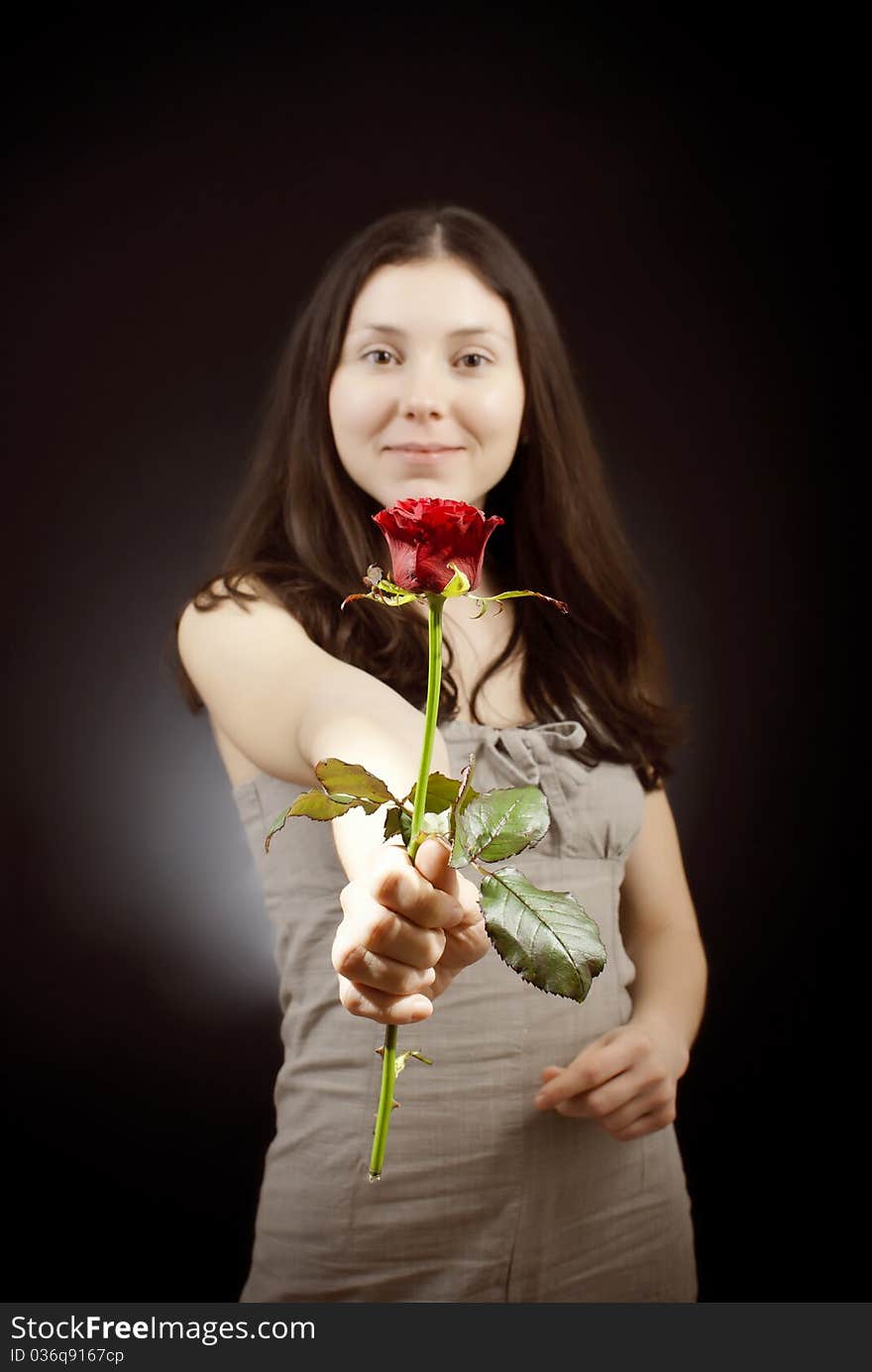 Beautiful girl in sarafan gives a red rose. Beautiful girl in sarafan gives a red rose