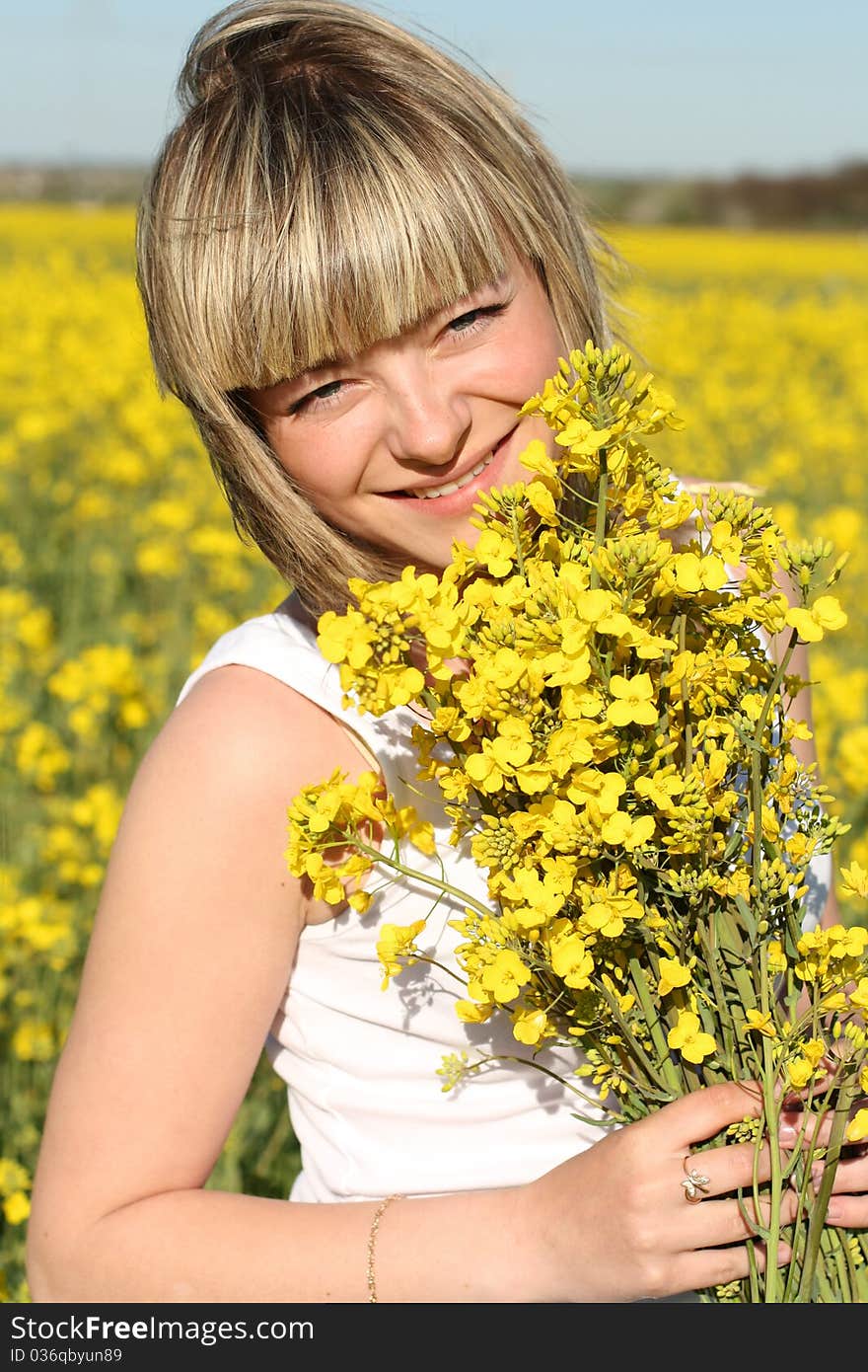 Portrait of young beautiful woman with natural make-up on blooming field in summer. Portrait of young beautiful woman with natural make-up on blooming field in summer