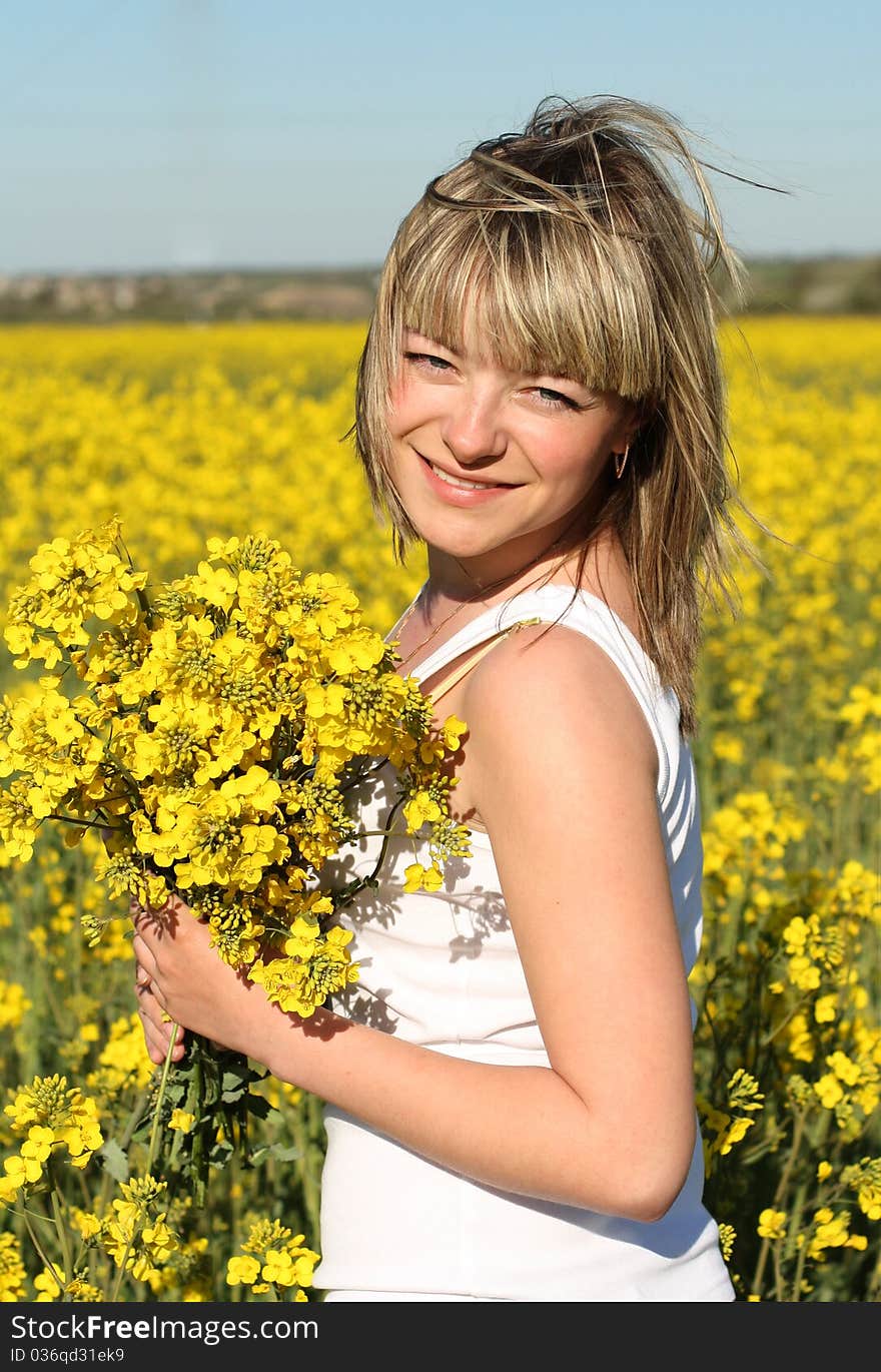 Portrait of young beautiful woman with natural make-up on blooming field in summer. Portrait of young beautiful woman with natural make-up on blooming field in summer