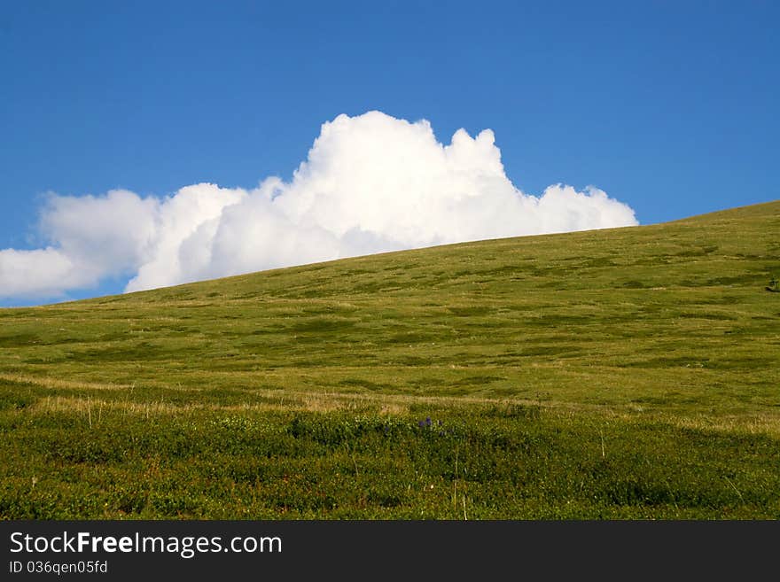 White Cloud Behind Green Hill