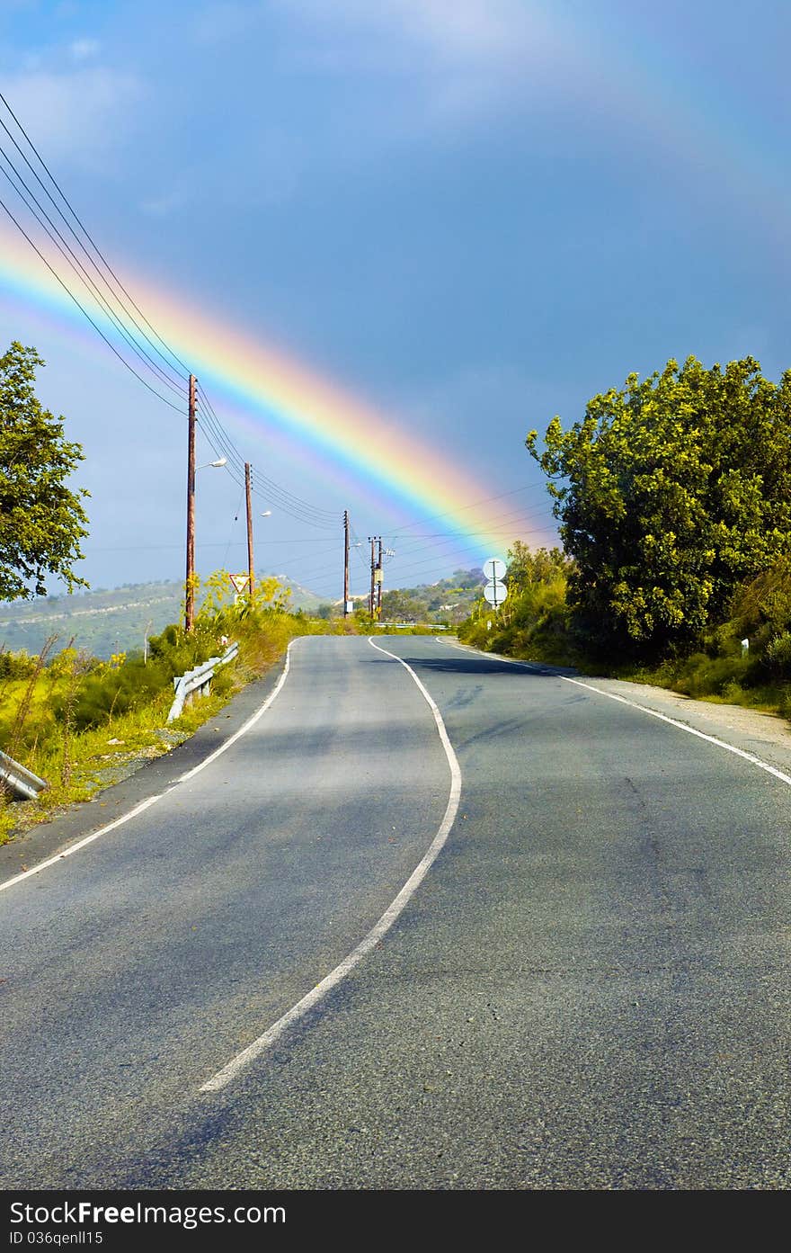 View at the beautiful rainbow above the road. View at the beautiful rainbow above the road