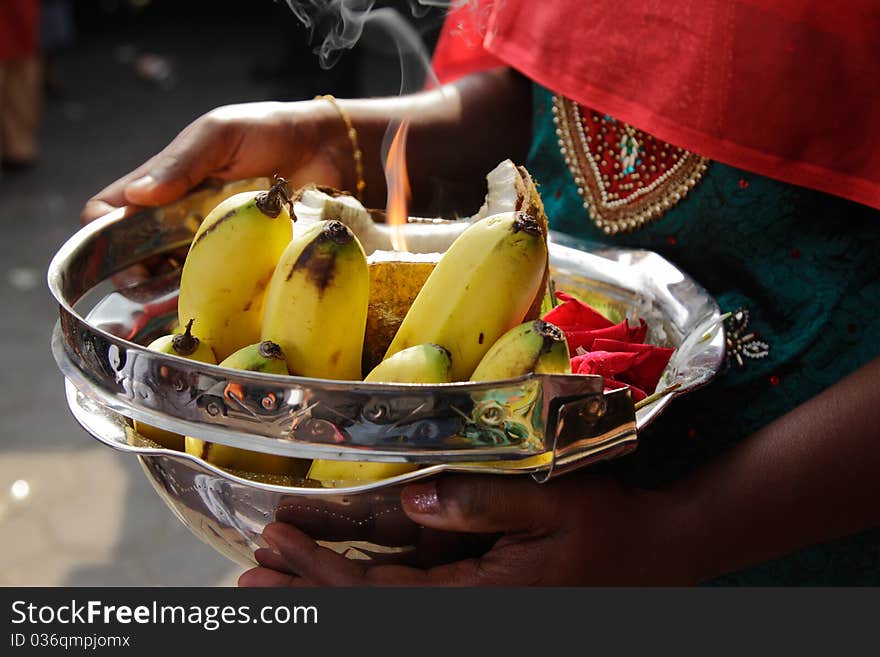 A woman holding a bowl of offerings during the Hindu festival of Thaipusam