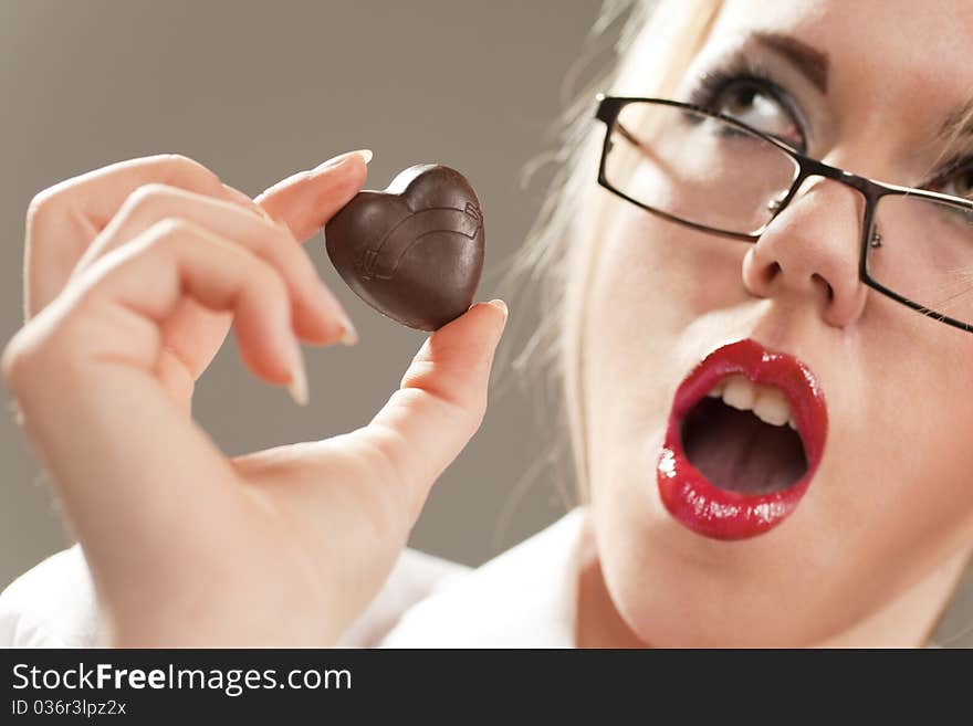 Pretty woman holding chocolate heart shaped candy