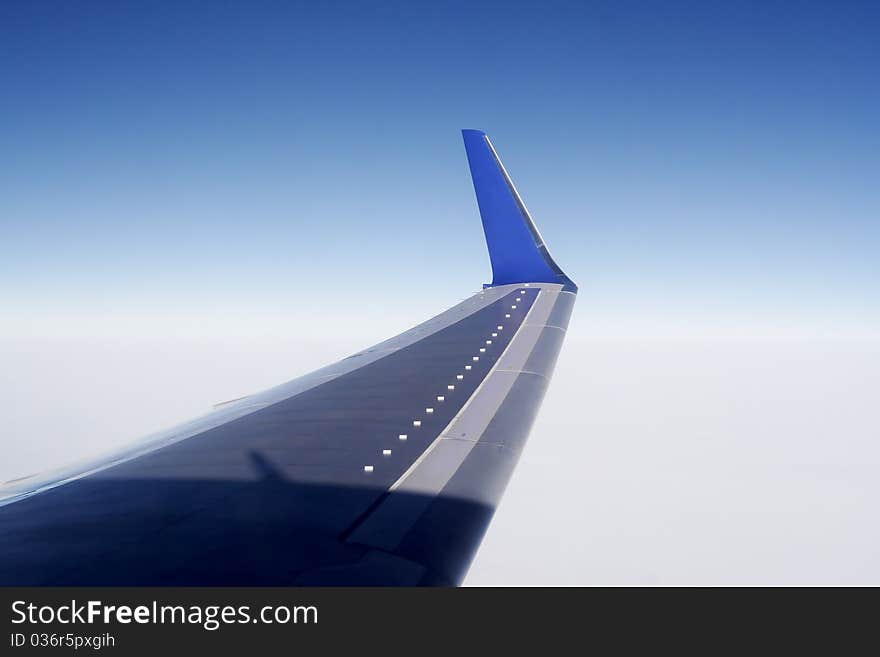 Wing aircraft in the sky. Blue sky and white skyline