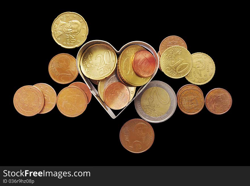 Coins isolated on the black background with clipping paths and metal heart. Coins isolated on the black background with clipping paths and metal heart.