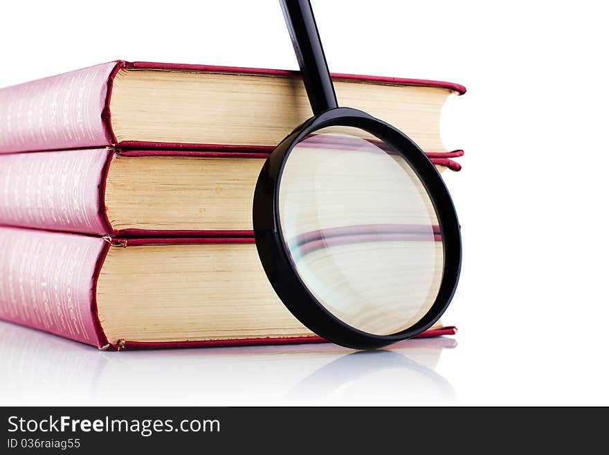 Old red books with a loupe on white background. Isolated. Old red books with a loupe on white background. Isolated.