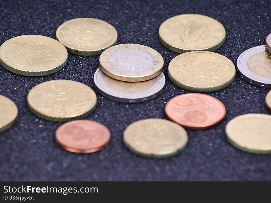 Euro coins arranged on black background