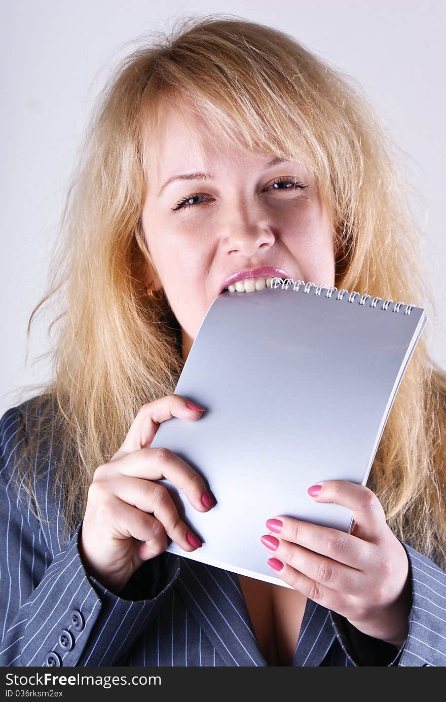 A girl gnaws a notebook