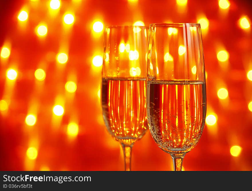 Two glasses of champagne  with  lights in the background. very shallow depth of field, focus on near glass.