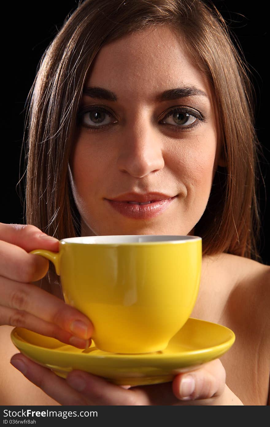 Portrait of a beautiful young caucasion woman holding a yellow tea cup and saucer. Portrait of a beautiful young caucasion woman holding a yellow tea cup and saucer.