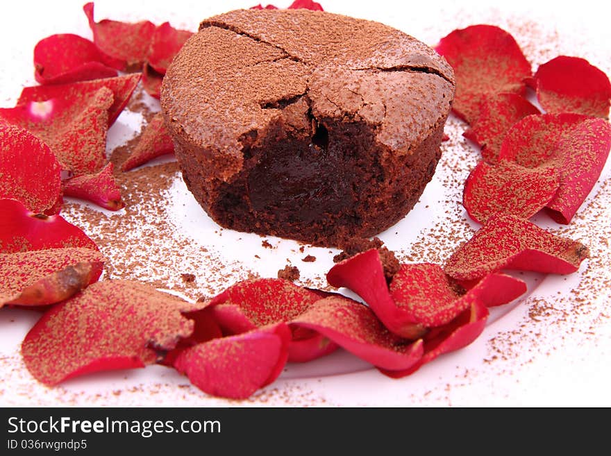 Chocolate souffle decorated with red rose petals and cocoa powder