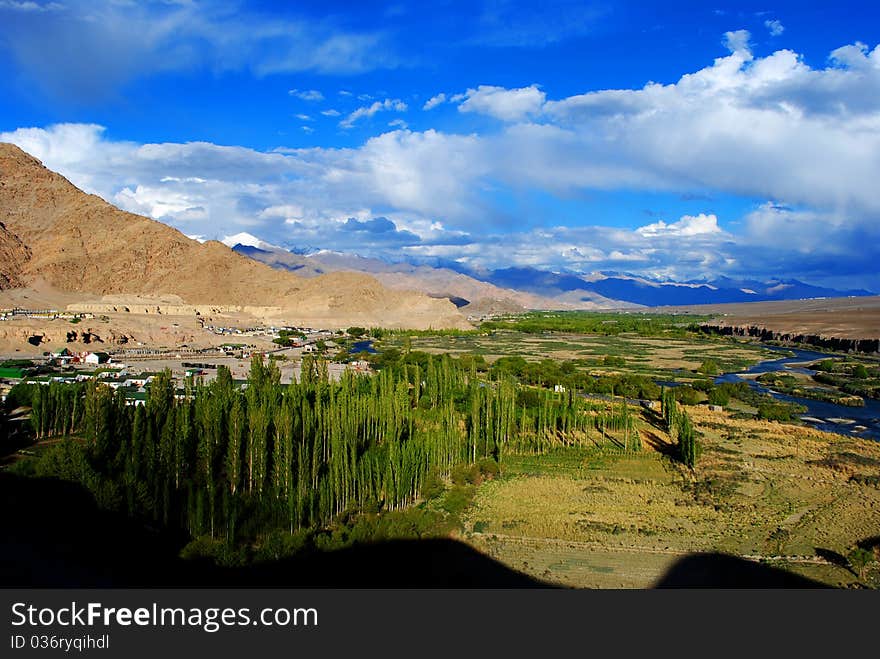 A beautiful and dramatic landscape with blue sky and white clouds and green trees. A beautiful and dramatic landscape with blue sky and white clouds and green trees.