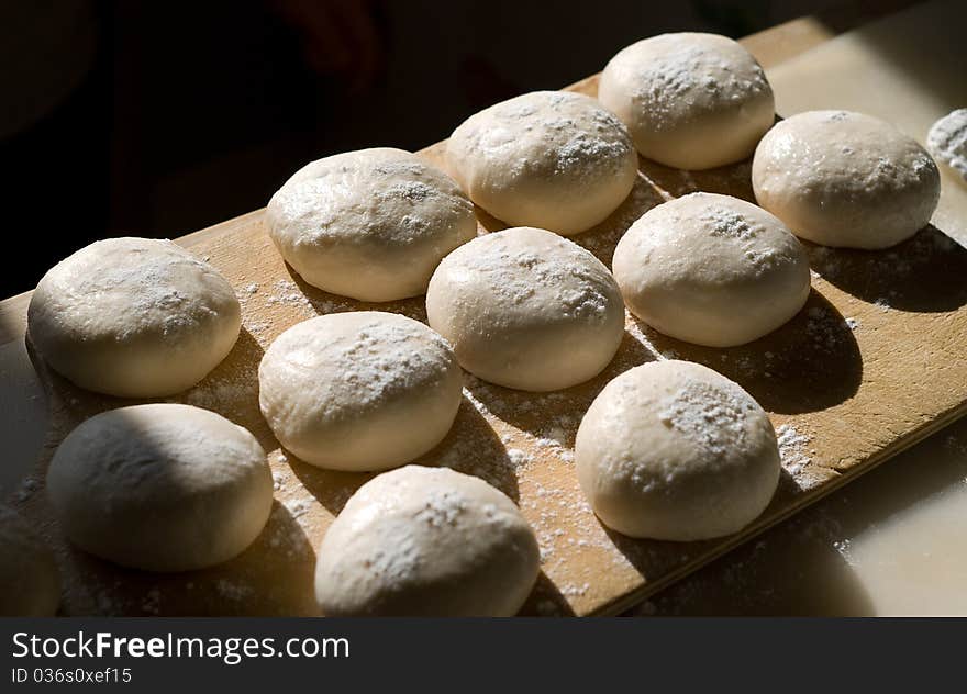 The balls of the dough powdered with a flour. The balls of the dough powdered with a flour