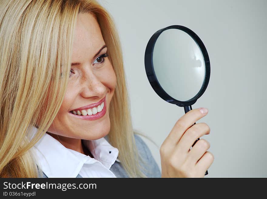 Business woman looking through a magnifying glass