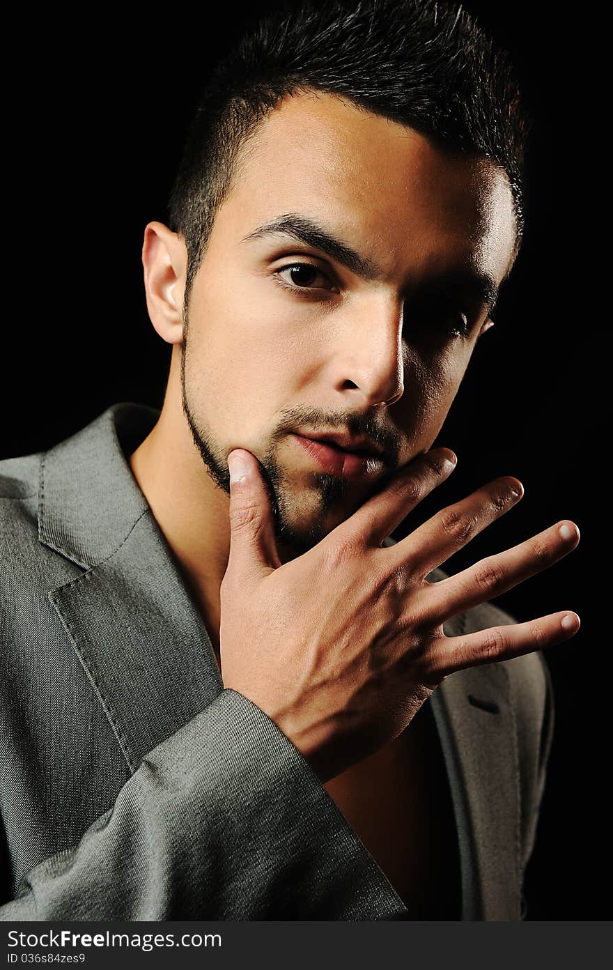 Young modern style macho man is posing , studio shot