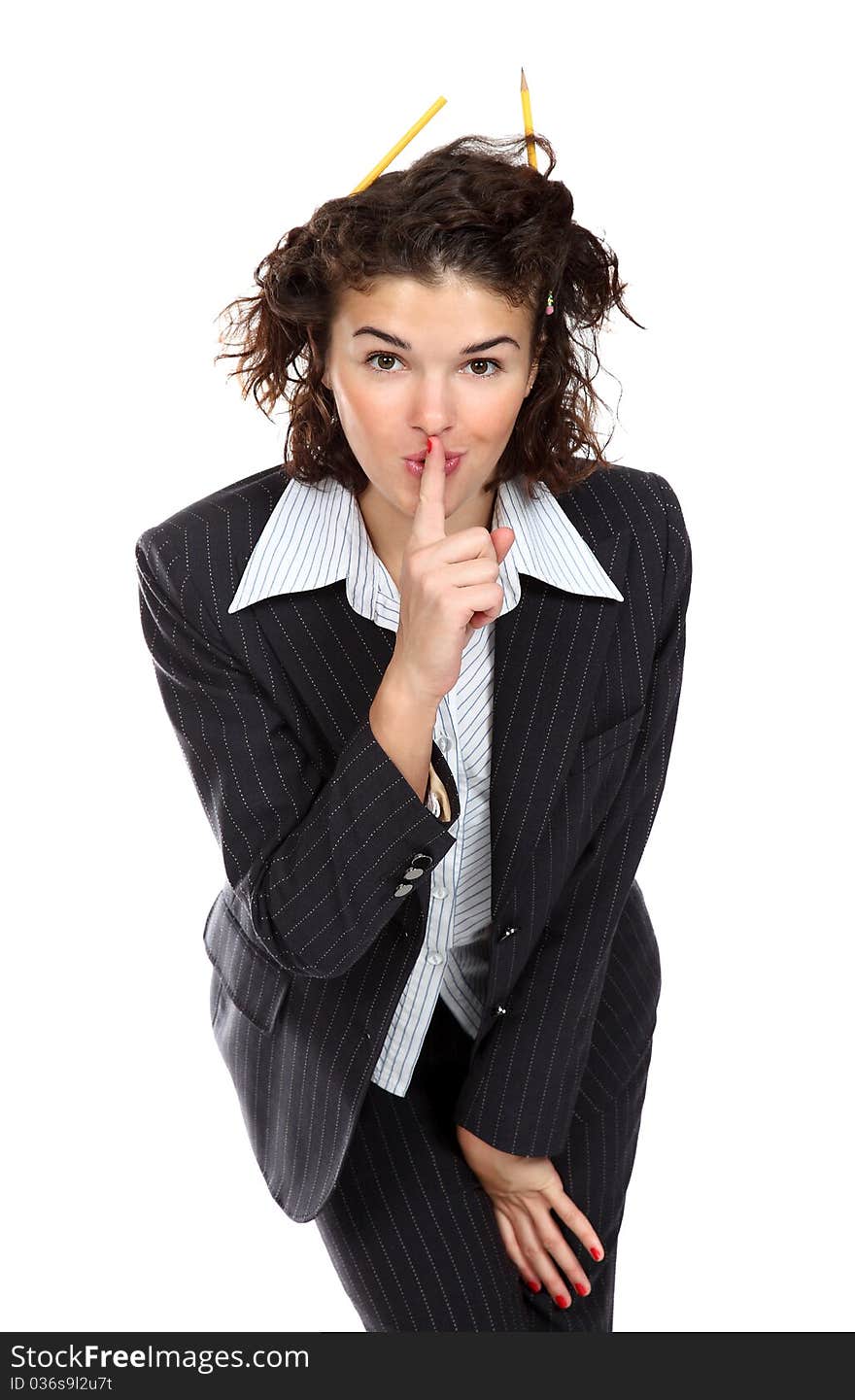 Pretty business woman with pencils in her hair gesturing to keep silence. Pretty business woman with pencils in her hair gesturing to keep silence