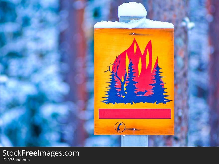 Yellow forest fire warning sign in nature.