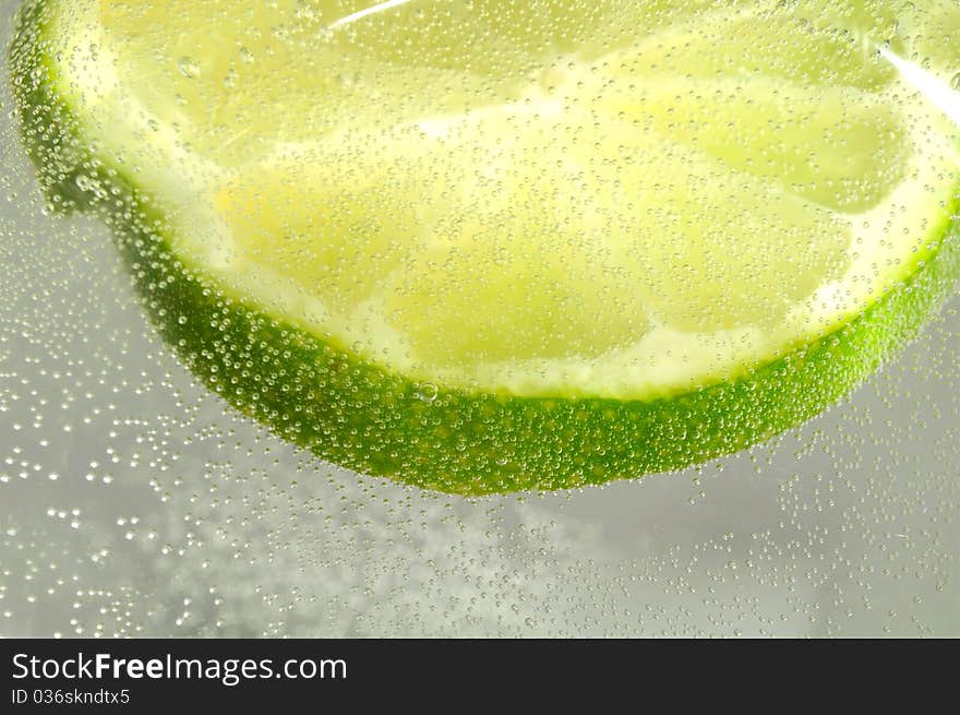 Slice of Lime in Water with Bubbles