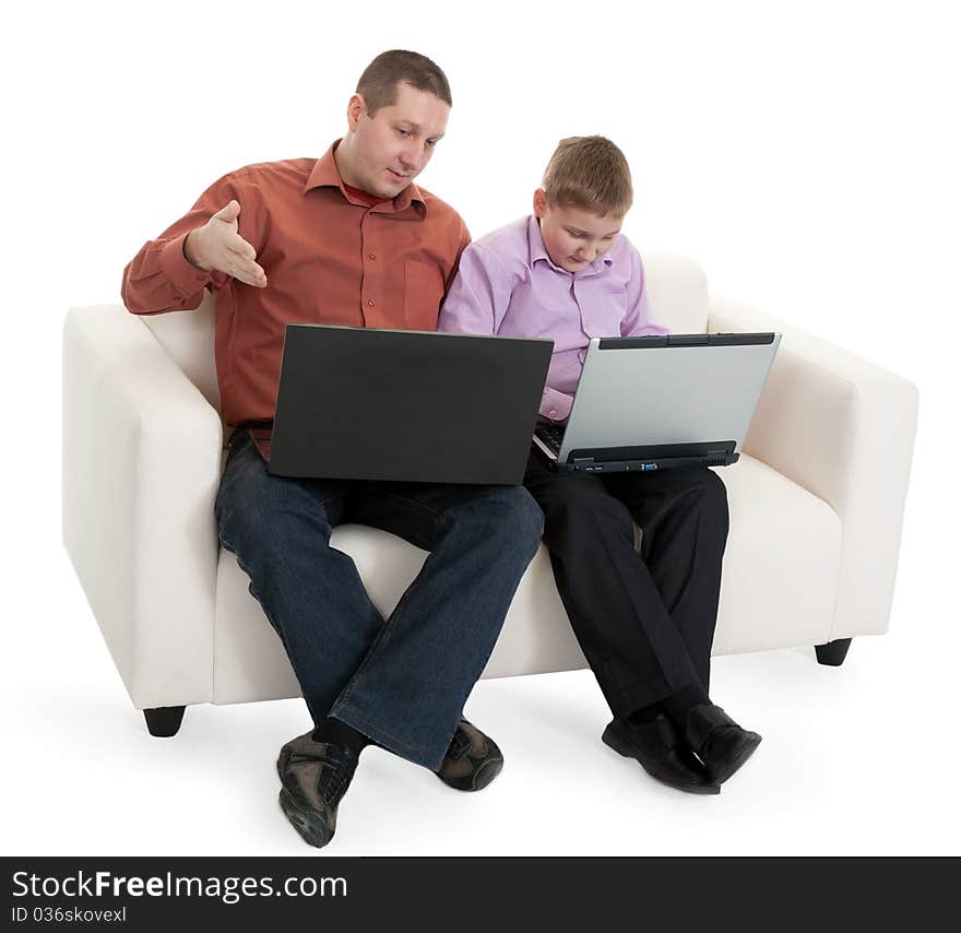 Father and son sitting on the couch with laptops