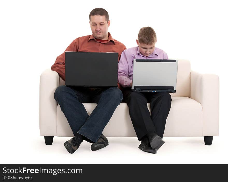 Father and son sitting on the couch with laptops